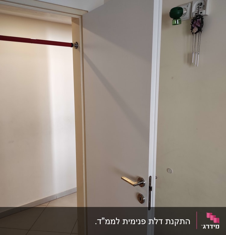 דלת לבנה פתוחה עם ידית מתכת כסופה